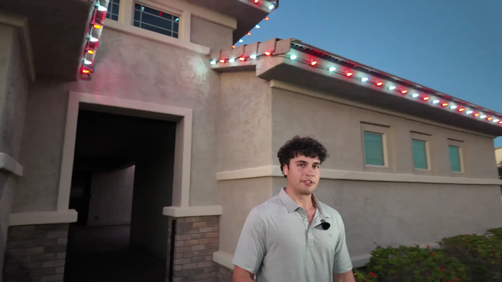 A Mesa home with red and white roofline lights at dusk